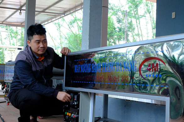 Anh Nở bên máy nướng bán tráng đa năng 4M của mình - Ảnh: TRẦN MAI